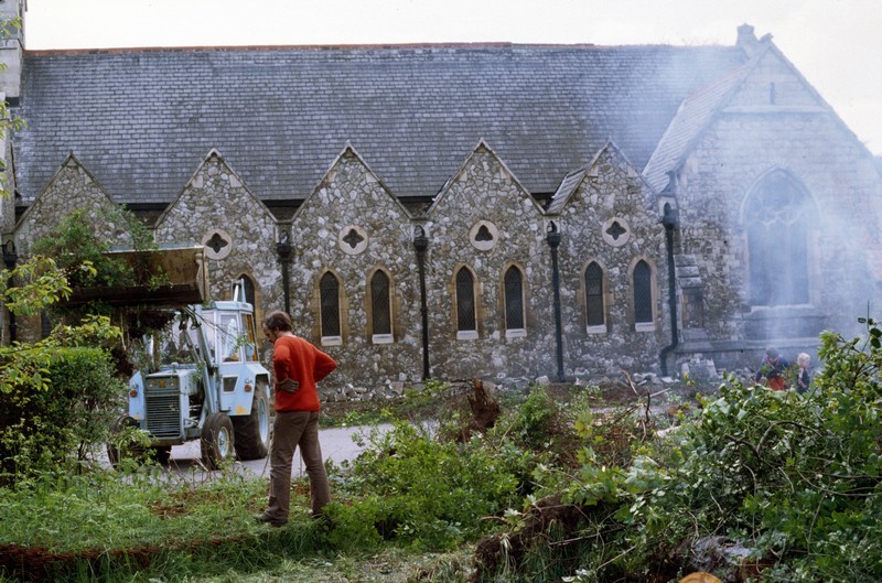 Photo showing the clearing of the orchard in front of the north wall, with a JCB and smoke visible
