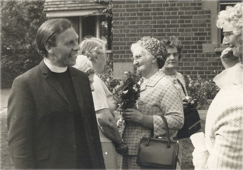 Peter Coombs chatting at the Women's Own 25th Anniversary celebration, with Gertrude Bartle in the background