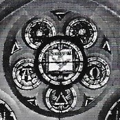 The circular section of the Alfred Streeter window highlighting the use of masonic symbols, one central circular window surrounded by 5 smaller circular windows arranged like a flower