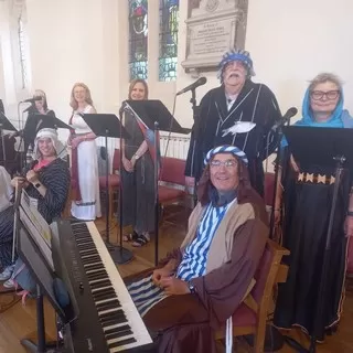 Music Group dressed in costume at the God's Big Plan service in 2022